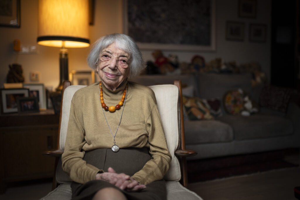 Fotografie von Margot Friedländer, in einem Sessels sitzend, die Hände im Schoß verschränkt